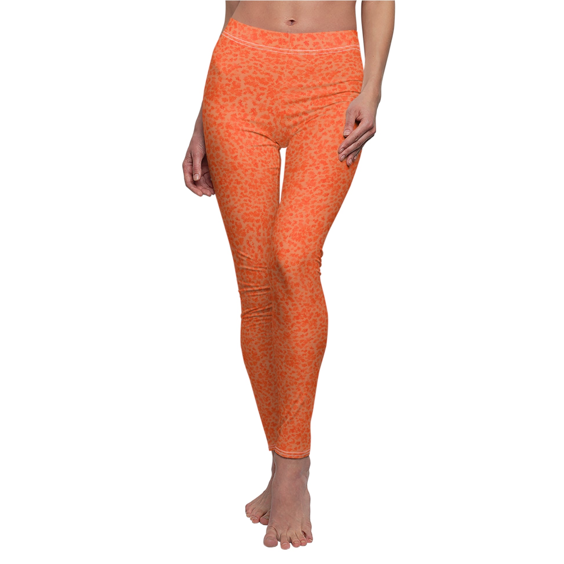 A pair of orange skinny fit leggings with a pattern, made from polyester and spandex fabric.