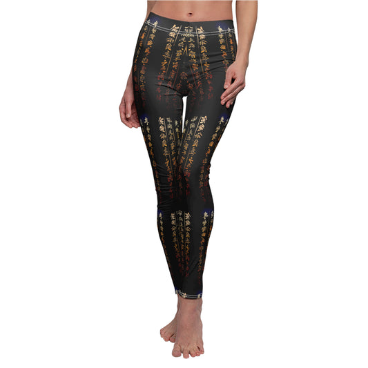 A model wearing a pair of black activewear leggings with a gold all-over Chinese calligraphy print, featuring a skinny fit design.