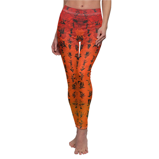 A pair of red and orange leggings with black character patterns, worn by a model posing with one hand on her hip.