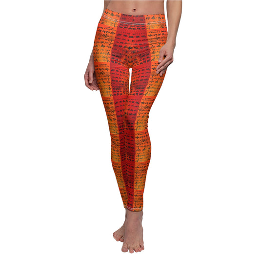 A pair of red and orange gradient skinny fit leggings with a text pattern, worn by a model posing on one leg.