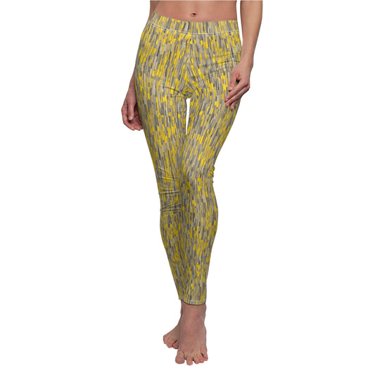 A pair of leggings with a vibrant yellow and gray geometric pattern, displayed on a model.