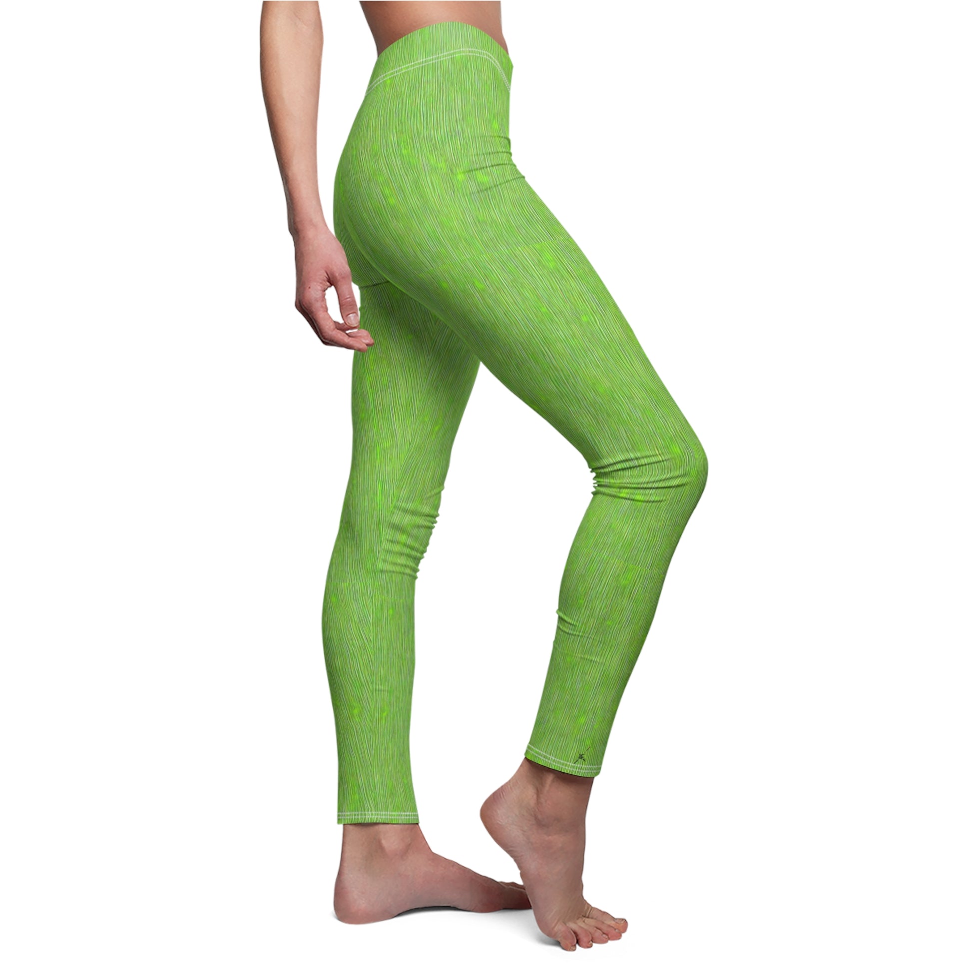 A pair of elastic skinny fit leggings in lime green with a white stripe pattern, worn by model, side view.