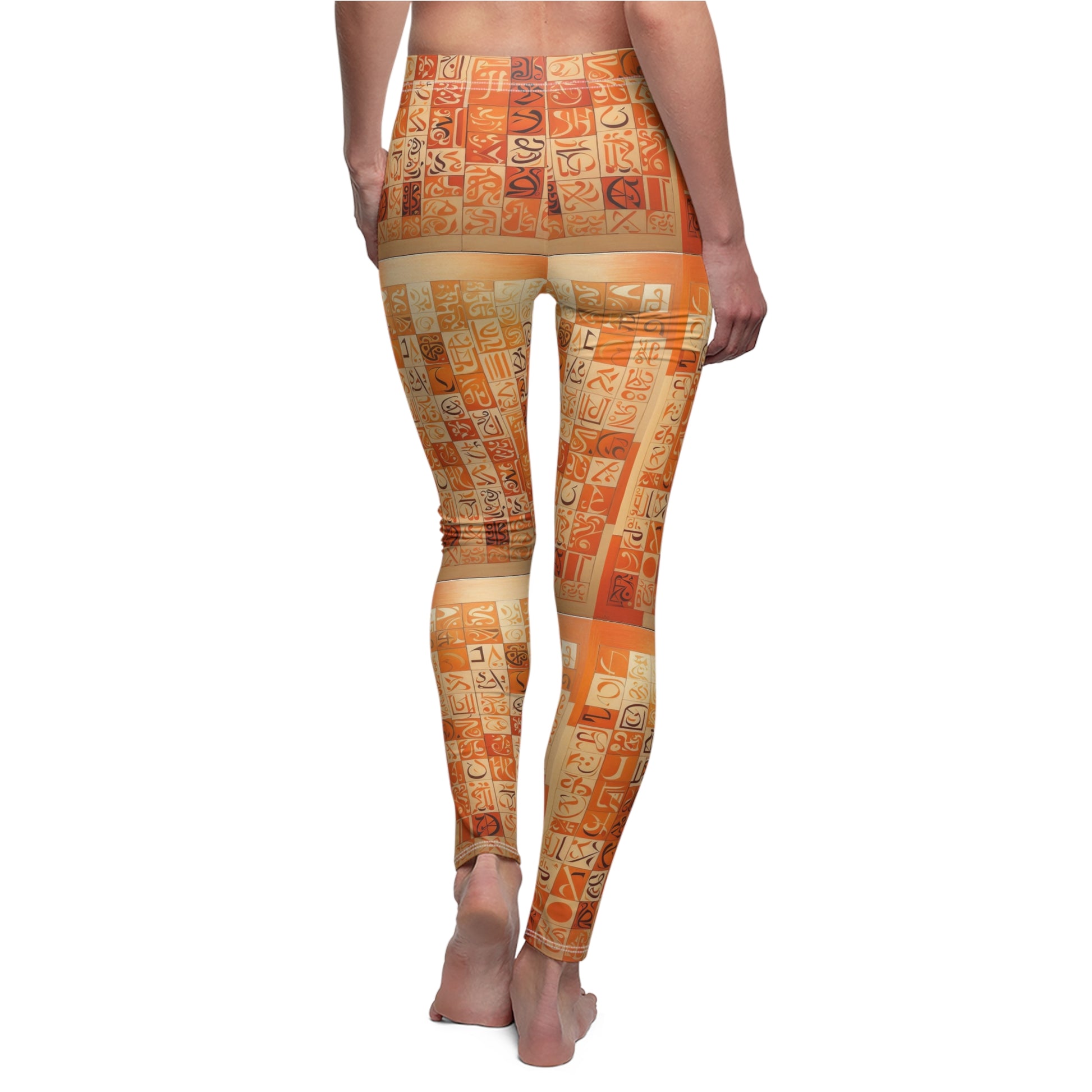 A pair of skinny fit leggings with geometric patterns in orange, creams, and browns with black and cream calligraphy on a female model, back view.